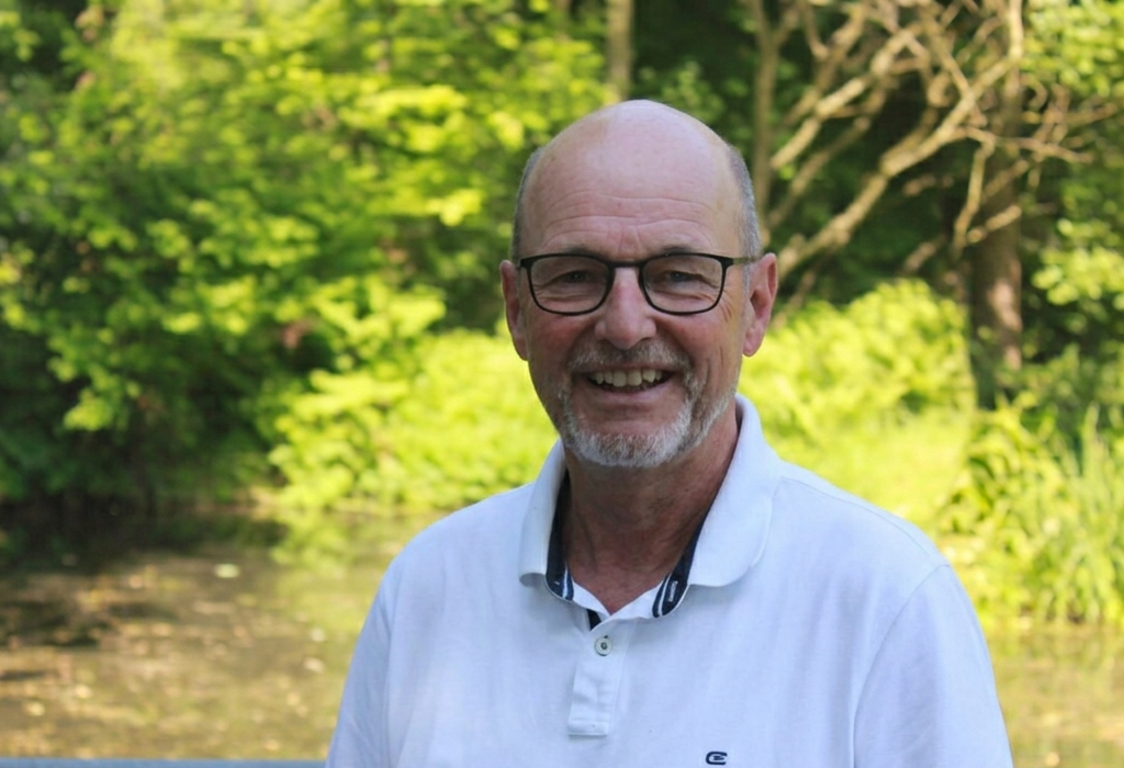 Mann mit Brille lächelt in die Kamera.