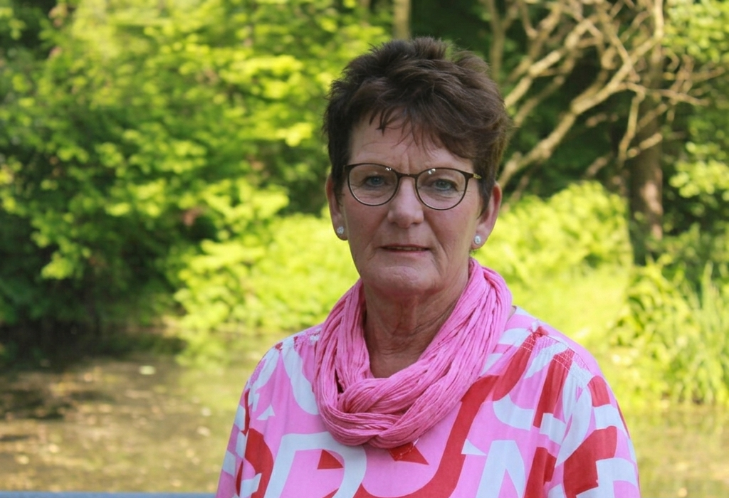 Frau mit Brille lächelt in die Kamera.