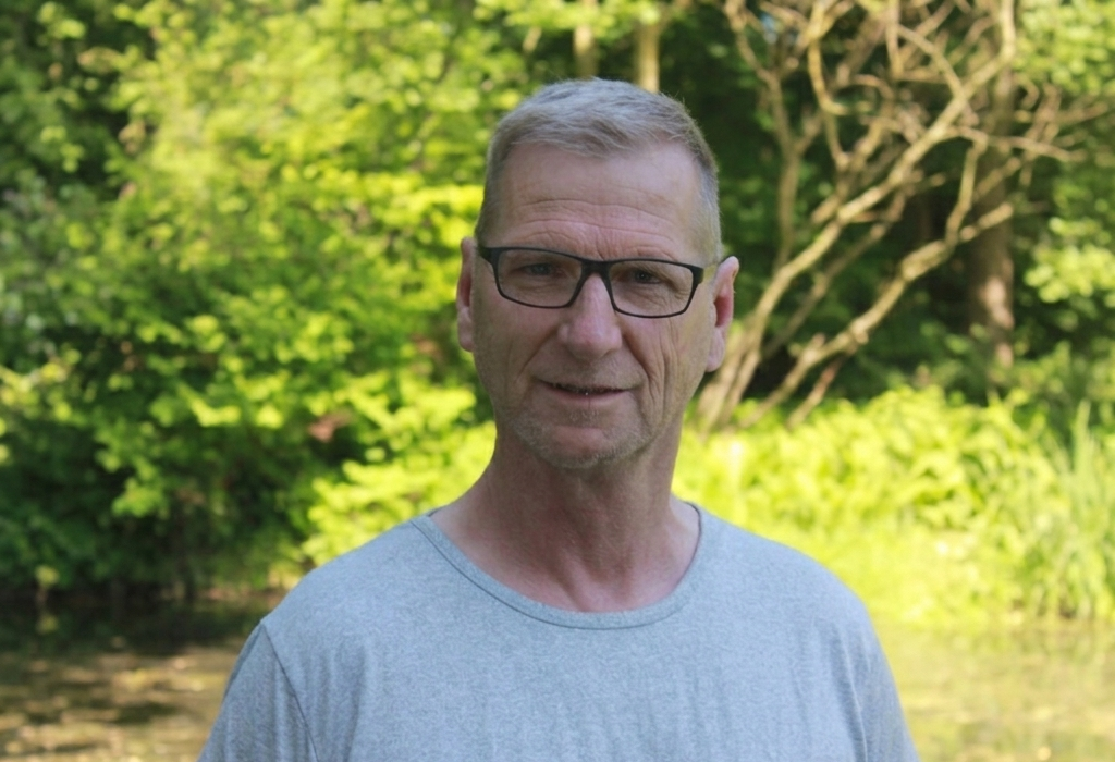 Mann mit Brille lächelt in die Kamera.