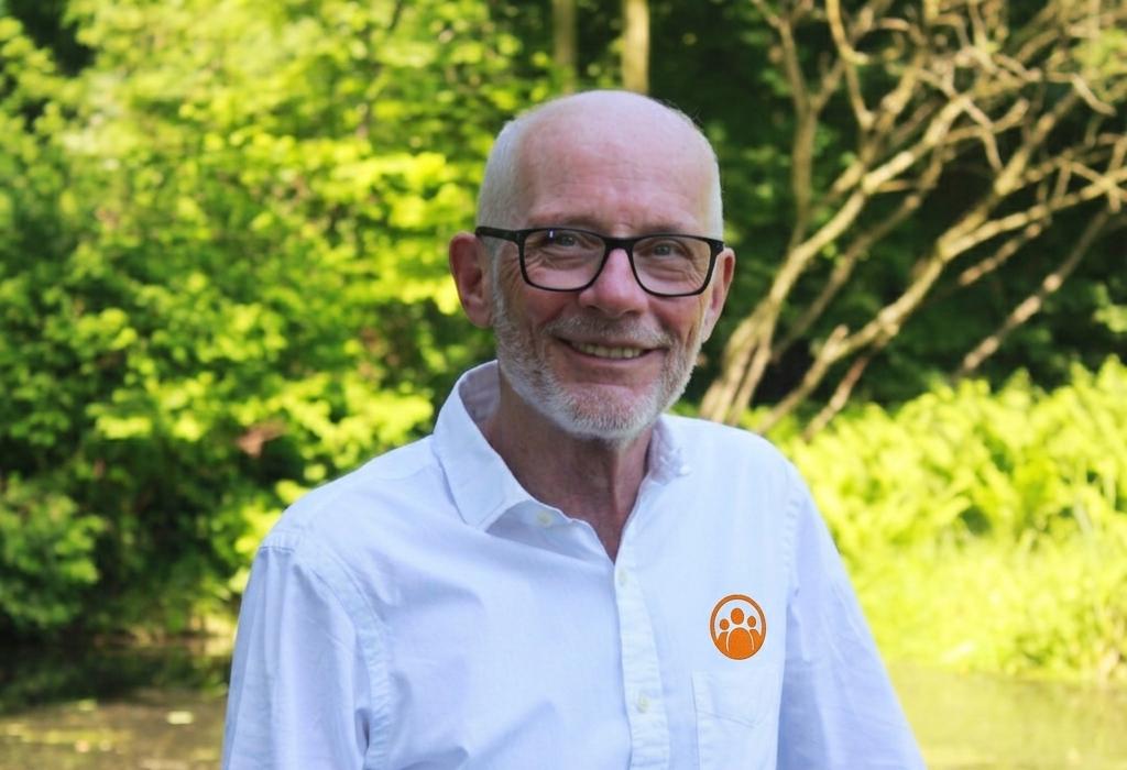 Mann mit Brille lächelt in die Kamera.